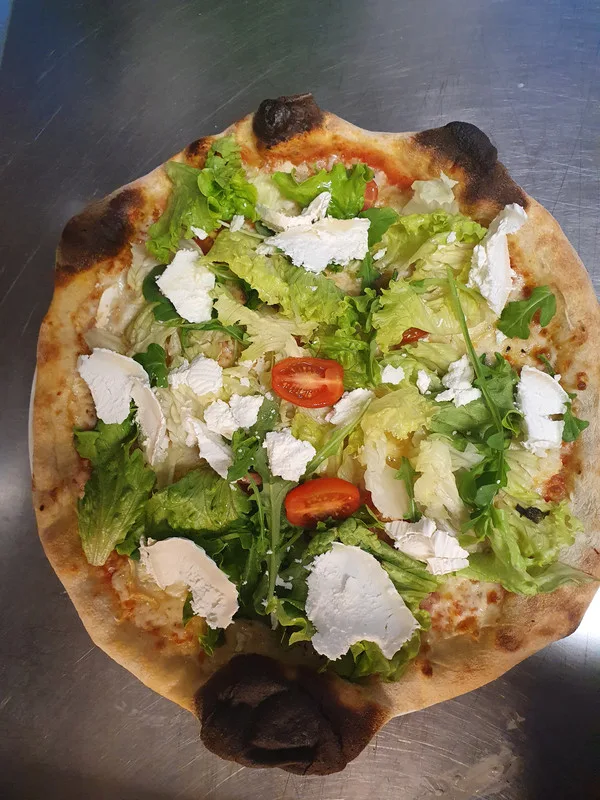 Pizza chèvre à la croûte dorée au feu, salade fraîche et tomates cerises.