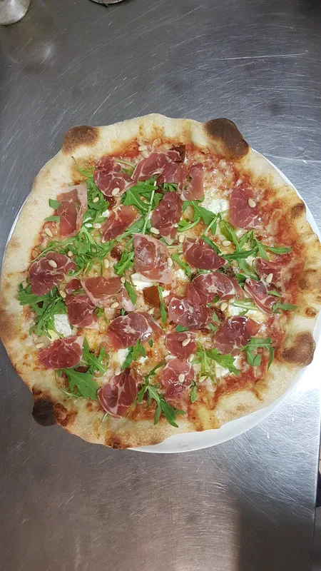 Pizza coppa, chèvre, roquette et pignons de pin.